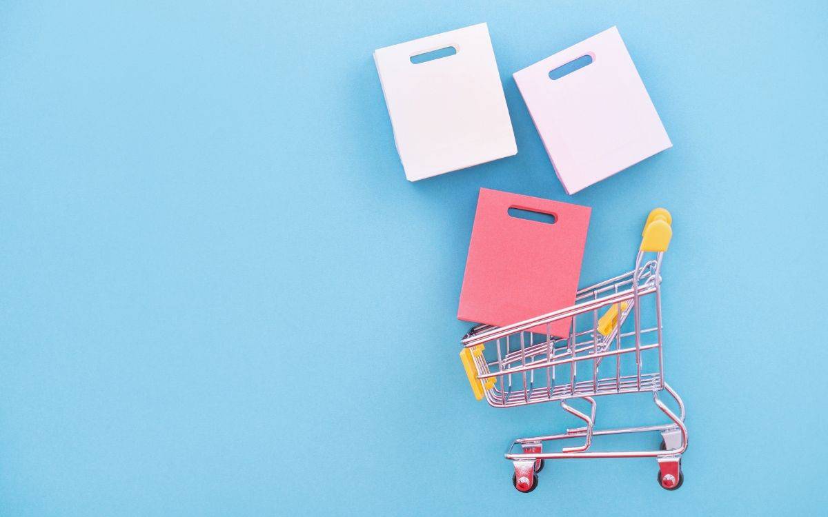 Digitala nyheter om Black Friday. Bild på en kundvagn med shoppingkassar.