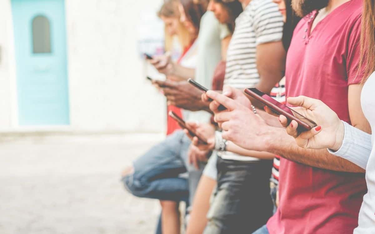Grupp människor som tittar på sina mobiltelefoner.