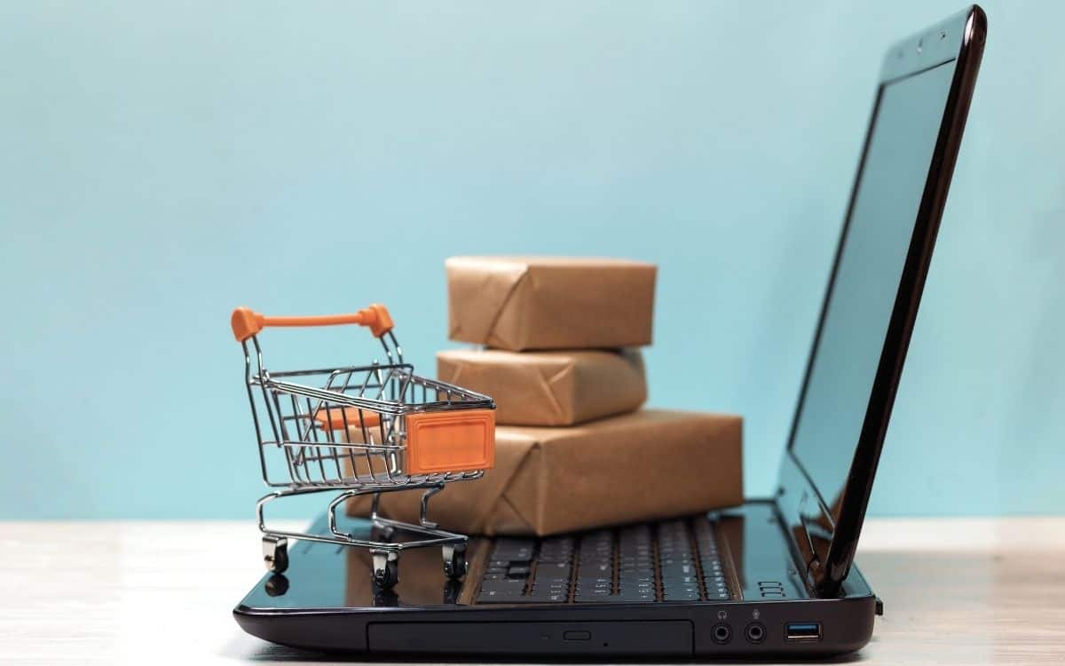 Bild på en liten kundvagn och små paket ovanpå en dator. Digitala nyheter om Google Shopping.
