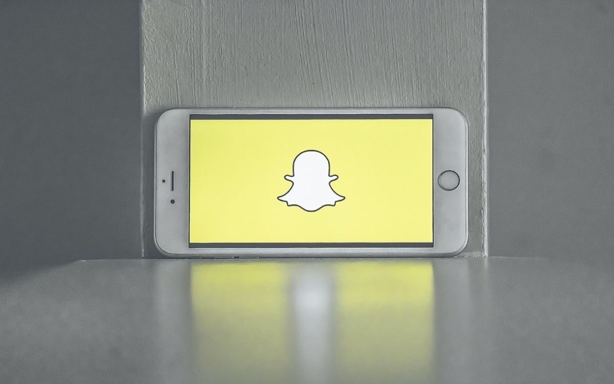 Bild på en mobil med Snapchat loggan