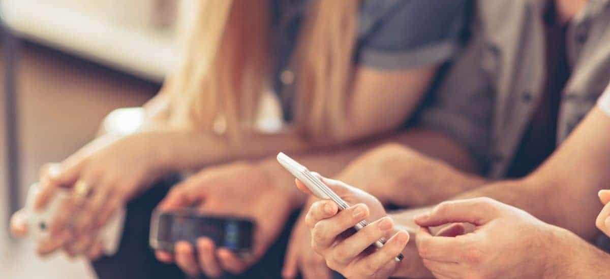 Grupp människor som tittar på en telefon 