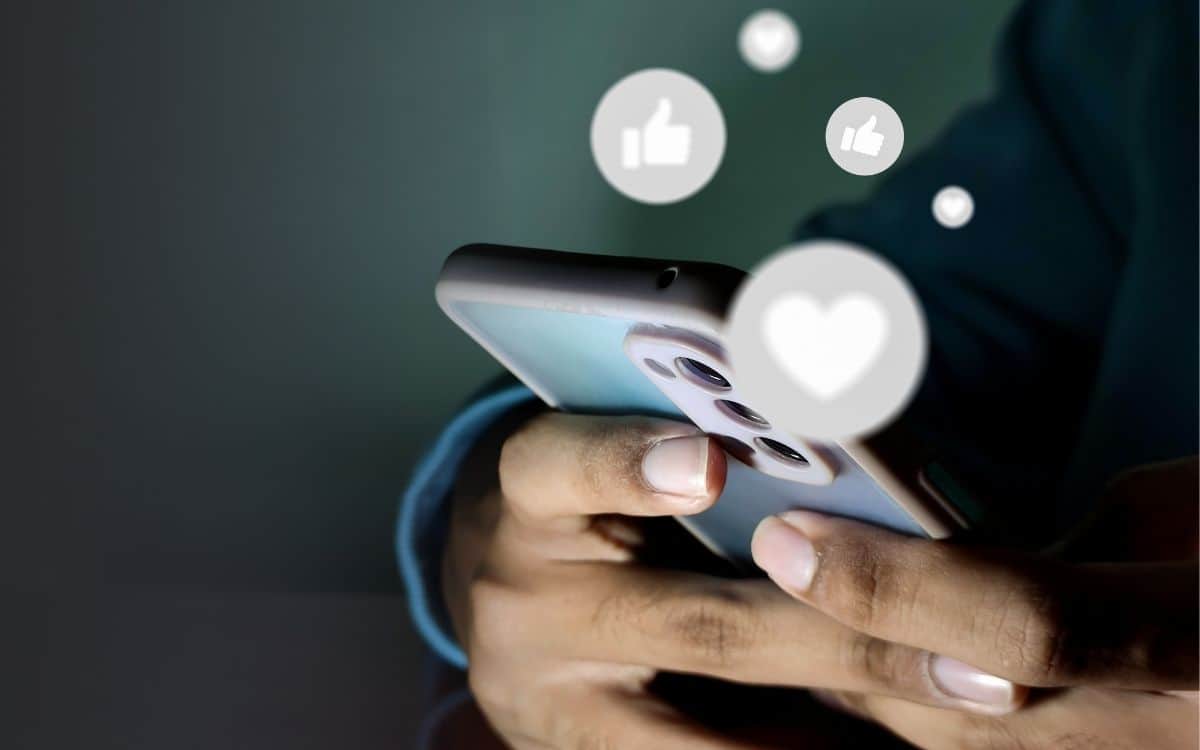 Bild på persons händer med en telefon som är aktiv på sociala medier.